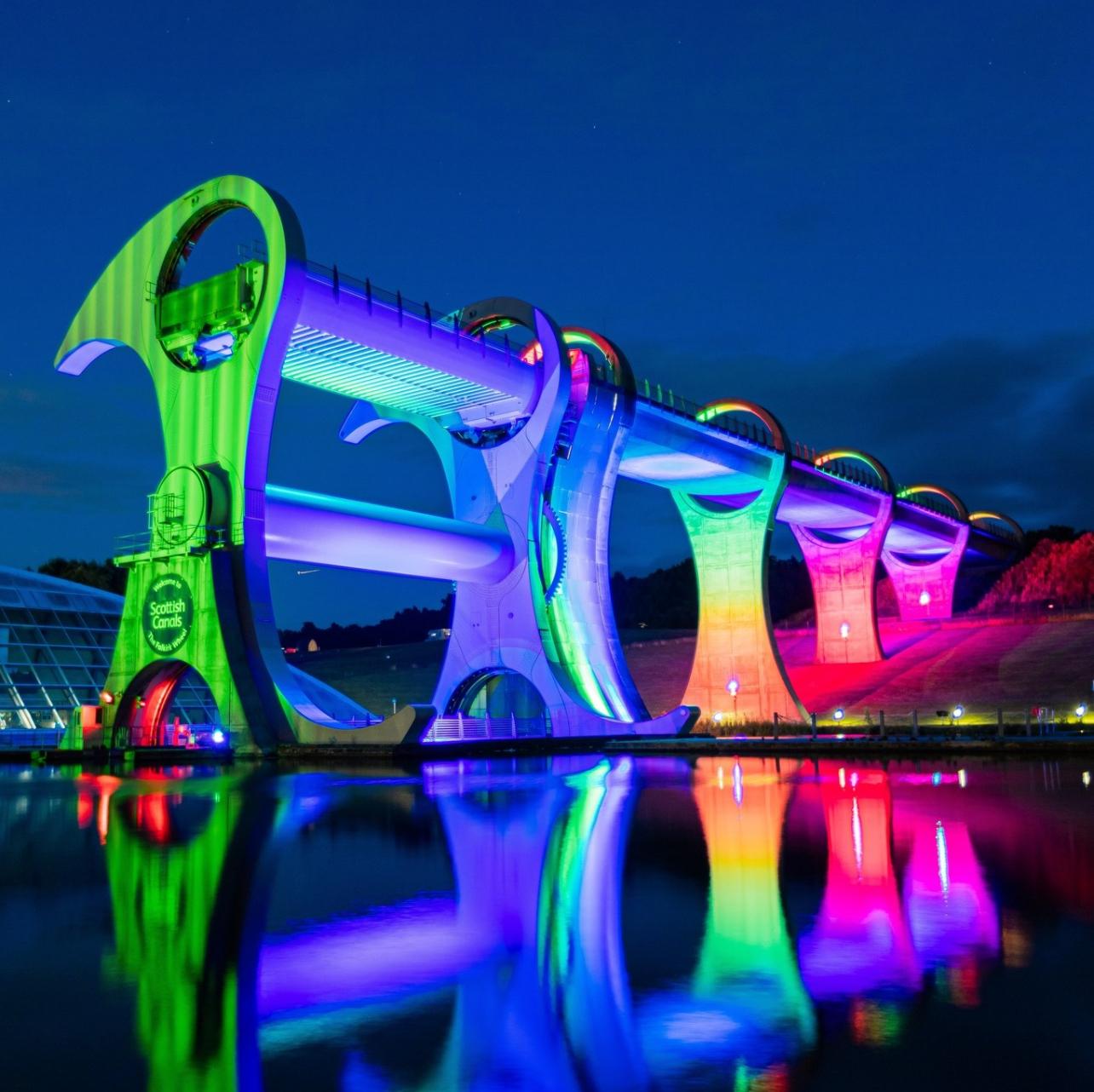 The Falkirk Wheel lit with colourful lights at night